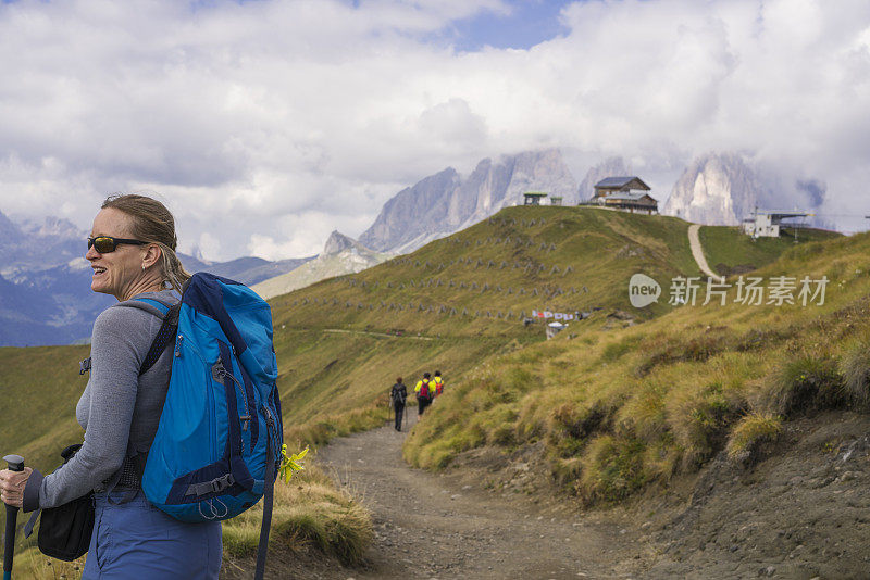 意大利北部Dolomites地区，一名老妇人在Viel dei Pan的陡峭山坡上徒步旅行，从Fedaia山口到Pordoi山口。